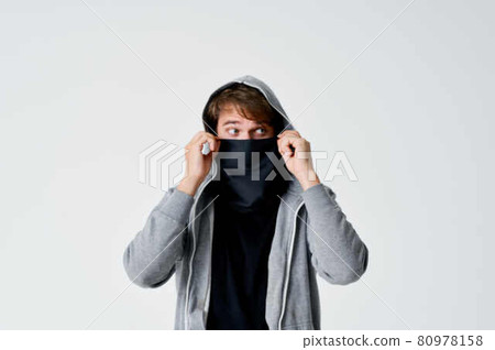 man hiding face in mask hooded sneaking stealing isolated background man hiding face in mask hooded sneaking stealing isolated background 80978158
