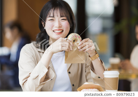 在咖啡館吃甜甜圈的女人 80979023