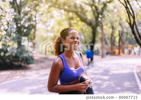 Portrait of black beautiful woman standing and resting after break workout at park,Happy and smiling,Relaxing time Portrait of black beautiful woman standing and resting after break workout at park,Happy and smiling,Relaxing time 80987715