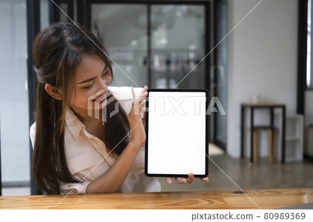 Young Asian woman showing digital tablet with blank screen. Young Asian woman showing digital tablet with blank screen. 80989369