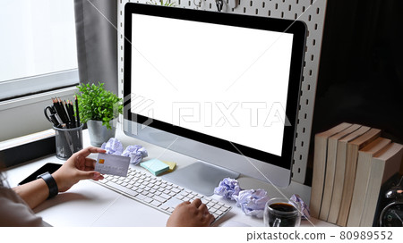 Woman holding credit card and using computer for online shopping at home. 80989552