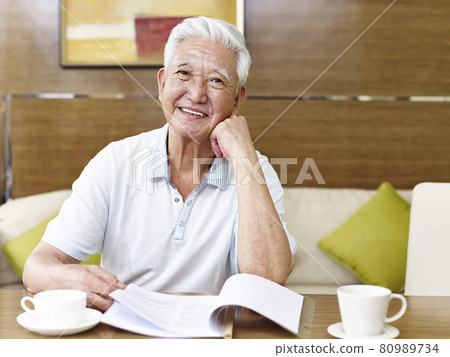 senior asian man reading a book or document in study room senior asian man reading a book or document in study room 80989734