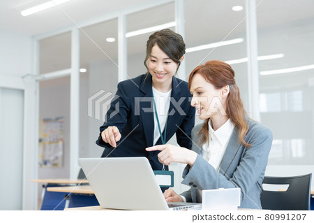 Two young Japanese and Western women talking while looking at a computer Photo cooperation: Japanese language school attached to Chuo College of Technology 80991207