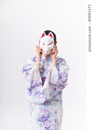A woman in a yukata holding a fox face in her hand 80991471
