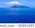 一個小島和一艘漂浮在藍色大海中的船 80991995