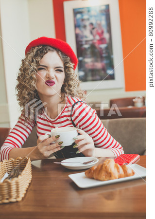 Young woman grimacing in cafe 80992288