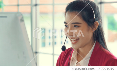 Businesswoman wearing headset working actively in office 80994059