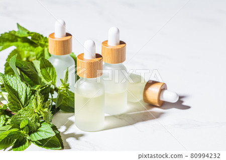Mint essential oil in glass bottles 80994232