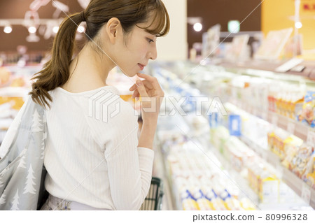 Female shoppers shopping while thinking about menus at the supermarket Female shoppers shopping while thinking about menus at the supermarket 80996328