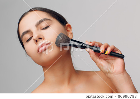 Portrait of young beautiful positive woman with nude make up and brush. Portrait of young beautiful positive woman with nude make up and brush. 80996788