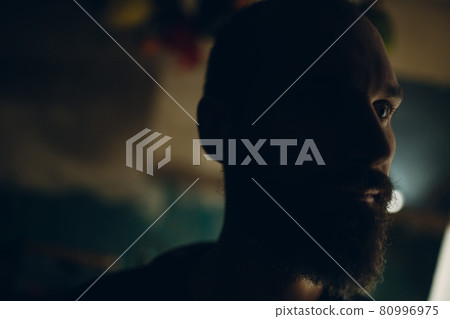 Backlit bearded adult man portrait in dark 80996975