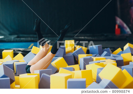 Young and beautiful woman plays in dry pool with cubes 80998874