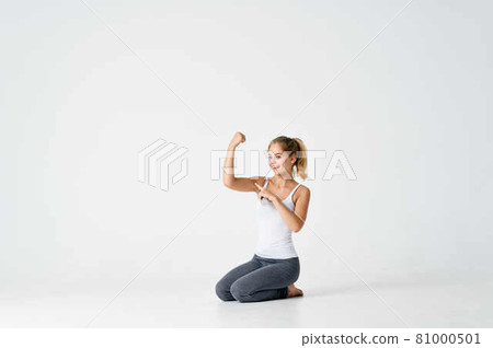 woman with dumbbells in her hands sitting on the floor exercise gym 81000501