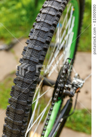 Bike waiting mechanic for repair in bicycle repair shop, outdoor. Bicycle wheel close up ready for examines, fixes modern cycle transmission system. Bike maintenance, sport shop concept. 81000980