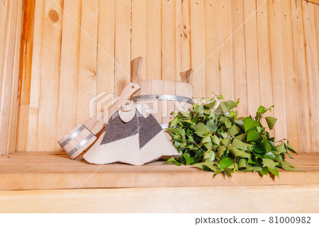 Traditional old Russian bathhouse SPA Concept. Interior details Finnish sauna steam room with traditional sauna accessories basin birch broom scoop felt. Relax country village bath concept. 81000982