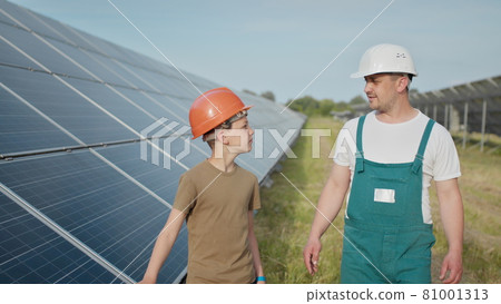 Engineer father is explaining to his little son an operation and performance of photovoltaic solar panels. Concept of Ecological Renewable Energy and Quality Family Time. Concept: renewable energy Engineer father is explaining to his little son an operation and performance of photovoltaic solar panels. Concept of Ecological Renewable Energy and Quality Family Time. Concept: renewable energy 81001313