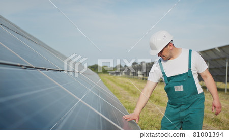 Engineer expert in solar energy photovoltaic panels. Man in hard helmet examining object. Concept of solar station development and green energy. Technology. Ecological concept. Engineer expert in solar energy photovoltaic panels. Man in hard helmet examining object. Concept of solar station development and green energy. Technology. Ecological concept. 81001394
