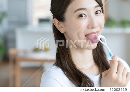 一位年輕女子在客廳刷舌頭 81002319