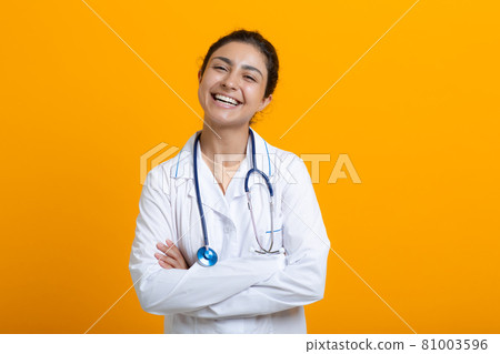 Portrait of indian doctor woman in white medical gown isolated on yellow background Portrait of indian doctor woman in white medical gown isolated on yellow background 81003596