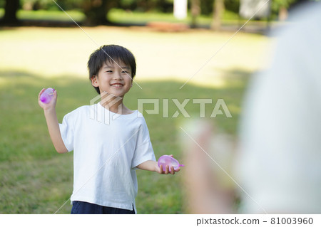 Parents and children playing with water balloons 81003960