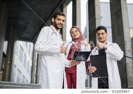 Arab medical students with xray, tablet and clipboard standing outdoors Arab medical students with xray, tablet and clipboard standing outdoors 81009967
