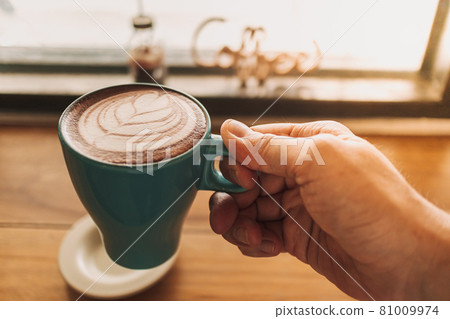Blue cup of coffee with full latte art on wooden table. Blue cup of coffee with full latte art on wooden table. 81009974