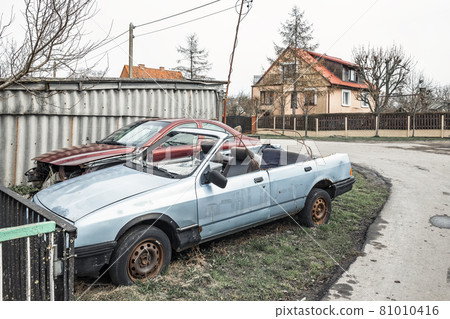 Two old wrecked cars with rusty tires, one without a roof 81010416