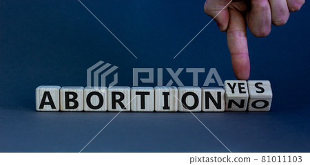 Abortion yes or no symbol. Male hand turns wooden cubes and changes words 'abortion yes' to 'abortion no' or vice versa. Beautiful grey background. Abortion yes or no concept, copy space. Abortion yes or no symbol. Male hand turns wooden cubes and changes words 'abortion yes' to 'abortion no' or vice versa. Beautiful grey background. Abortion yes or no concept, copy space. 81011103