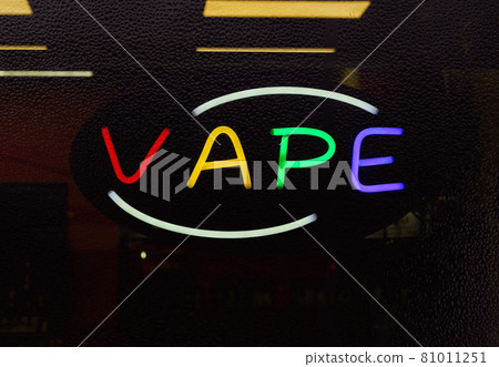 Colorful Neon Vape Sign in Rainy Smoke Shop Window, Focus on Neon Letters 81011251