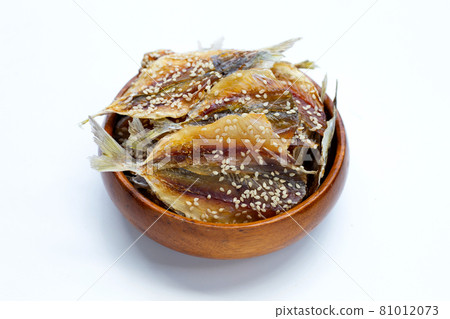 Dried fish with sesame seeds in wooden bowl on white background. Dried fish with sesame seeds in wooden bowl on white background. 81012073