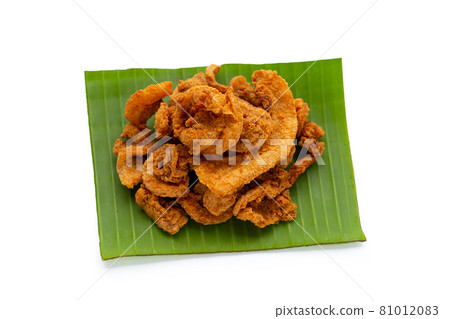 Fried crispy pork belly recipe on banana leaf on white background. 81012083