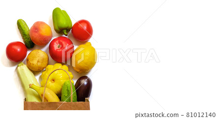 A paper shopping bag with vegetables and fruits, tomato, cucumber, squash, pepper, lemon, eggplant, zucchini, banana, apple, peach on white background A paper shopping bag with vegetables and fruits, tomato, cucumber, squash, pepper, lemon, eggplant, zucchini, banana, apple, peach on white background 81012140
