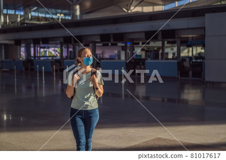 Woman in mask at empty airport at check in in coronavirus quarantine isolation, returning home, flight cancellation, pandemic infection worldwide spread, travel restrictions and border shutdown Woman in mask at empty airport at check in in coronavirus quarantine isolation, returning home, flight cancellation, pandemic infection worldwide spread, travel restrictions and border shutdown 81017617
