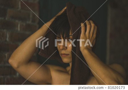 Young man wiping hair with towel 81020173