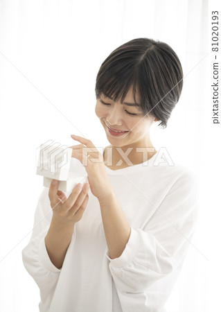 A woman who opens the box and tries on a wedding ring 81020193