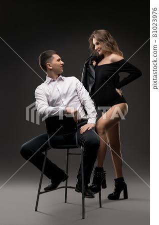 Stylish couple standing on gray background in studio Stylish couple standing on gray background in studio 81023976