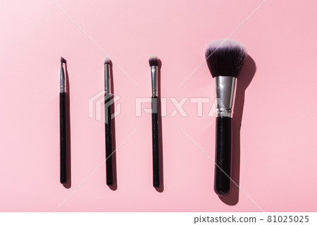 Various make-up brushes on pink background, top view. Cosmetics and beauty concept. 81025025