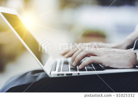 在戶外使用筆記本電腦的人手邊特寫綠色背景模糊 在戶外使用筆記本電腦的人手邊特寫綠色背景模糊 81025332