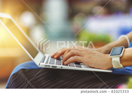 在戶外使用筆記本電腦的人手邊特寫綠色背景模糊 在戶外使用筆記本電腦的人手邊特寫綠色背景模糊 81025333