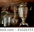 Vintage old antique dusty bottles decanter samovar, cobweb in an old abandoned house, on a wooden background. 81026355
