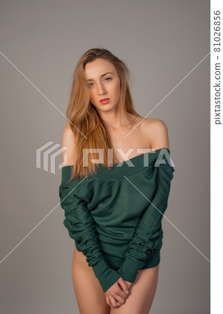 Beautiful young woman posing in emerald jumper Beautiful young woman posing in emerald jumper 81026856