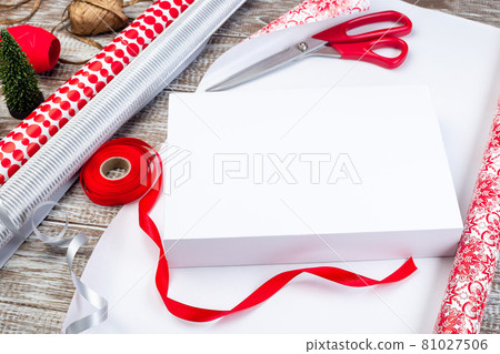 Wrapping Christmas gift box, different wrapping paper and ribbons on table, horizontal 81027506