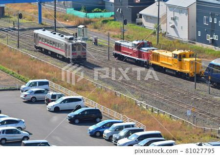 A regular train bound for Kushiro that goes beside "THE ROYAL EXPRESS" waiting for locomotive replacement work 81027795