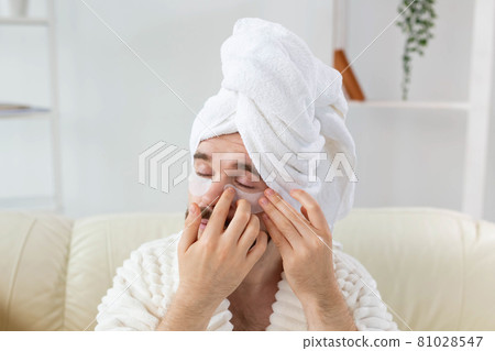 Bearded man applying eye patches on his face. Wrinkles and face home care for men. Bearded man applying eye patches on his face. Wrinkles and face home care for men. 81028547