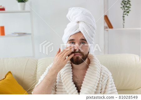 Bearded man applying eye patches on his face. Wrinkles and face home care for men. Bearded man applying eye patches on his face. Wrinkles and face home care for men. 81028549