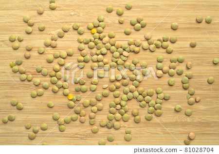 Green lentil grains on bamboo cutting board 81028704