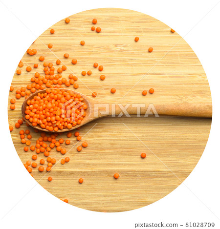 Red and orange lentil grains in wooden spoon, on bamboo cutting board 81028709