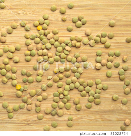 Green lentil grains on bamboo cutting board 81028724