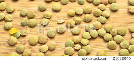 Green lentil grains on bamboo cutting board 81028940