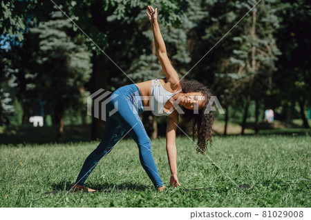 attractive young woman performing morning exercises, outdoors . 81029008